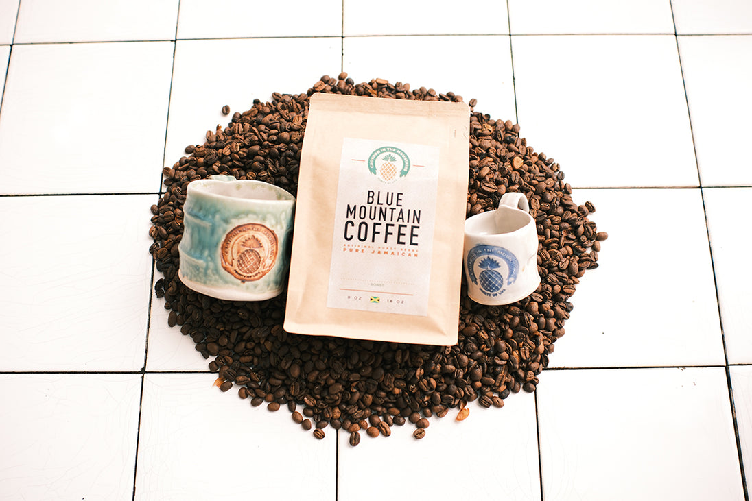 Blue Mountain Coffee package with coffee beans and mugs on a tiled floor. Best coffee beans top selling coffee beans, birthday gift for college, top quality coffee, fresh coffee beans, best coffee gift, Jamaica Blue Mountain coffee, single estate, coffee beans, organic coffee, coffee lovers, purist coffee, mother day gift for mom, birthday gift 2025, best coffee beans, father day gift 2026, coffee gift ideas, gift ideas, gift for coffee lovers, organic coffee beans, great birthday gift, best gift ideas, Chr